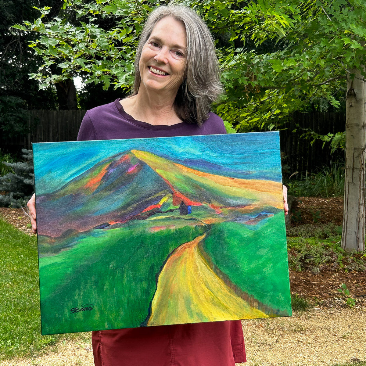 Artist Sally Evans holding The Path Home 18 x 24 acrylic painting